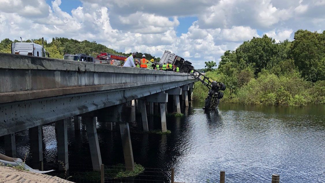 A truck lost control on I-75 and ended up partially dangling over a bridge in Sumter County Monday. (FHP)