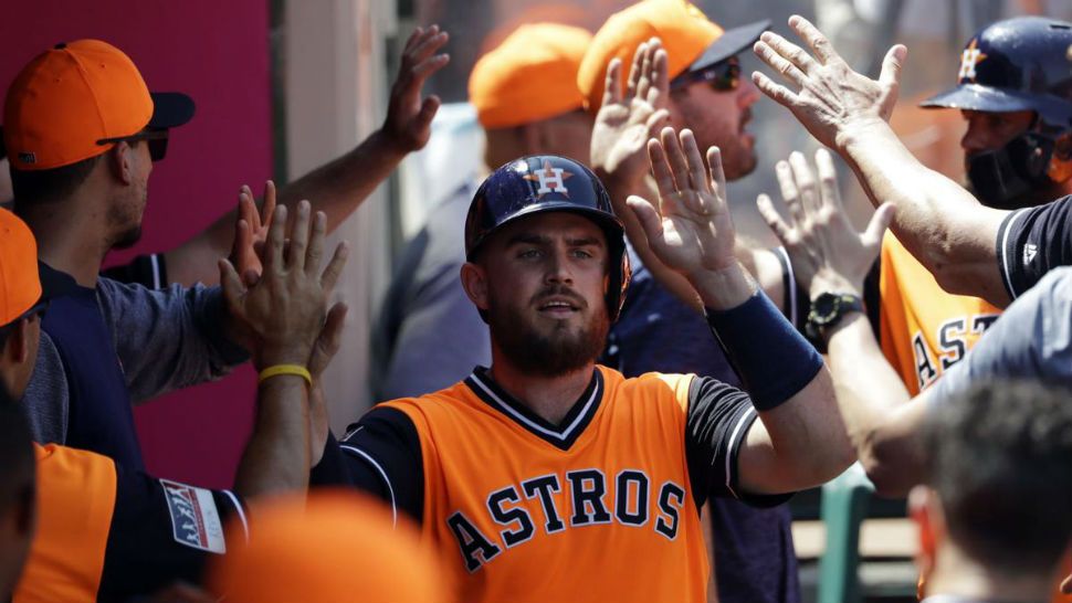 Houston Astros' Max Stassi is high-fived in the dugout after scoring on a single from Carlos Correa during the third inning of a baseball game Sunday, Aug. 26, 2018, in Anaheim, Calif. (AP Photo/Marcio Jose Sanchez)
