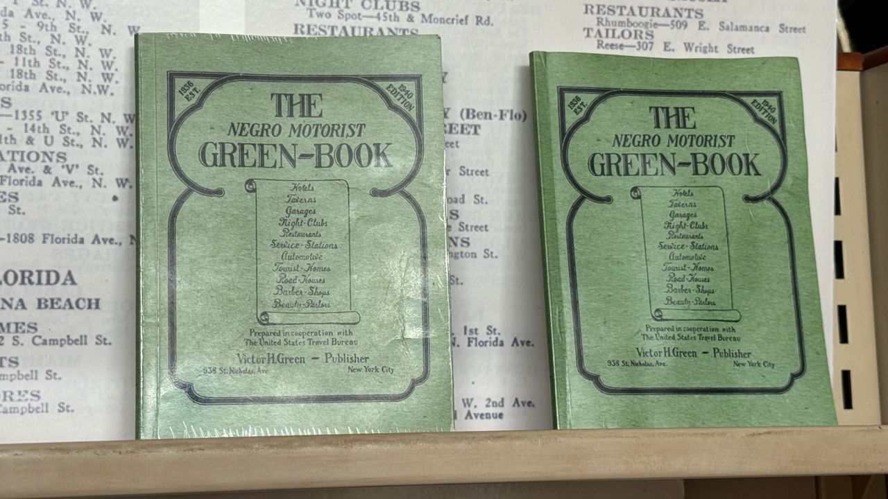 The museum's interim executive director showed us green books that include a list of hotels safe and welcoming for African-American travelers during a different era. (Spectrum News/Keith Landry)