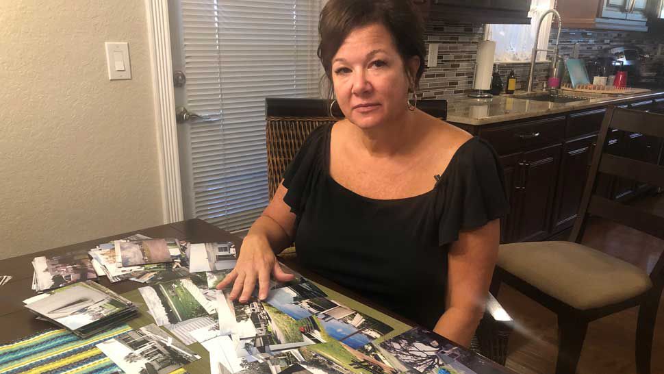 Parakeet Mobile Home Park co-owner Lynn Henry with her photographs showing the damage her community sustained following Hurricane Charley. (Stephanie Claytor/Spectrum Bay News 9)