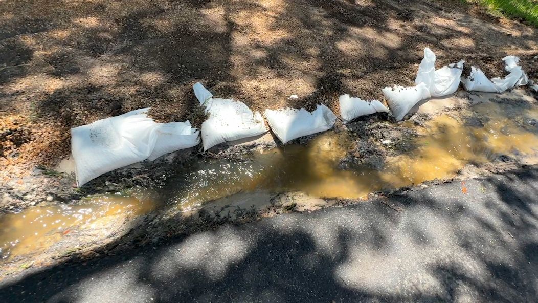 Crews lined up sandbags in front of people’s homes and yards to redirect the water to a manhole in the street. The county says that once the crack is located, it could take several weeks to resolve the issue. (Spectrum Bay News 9/Julia Hazel)