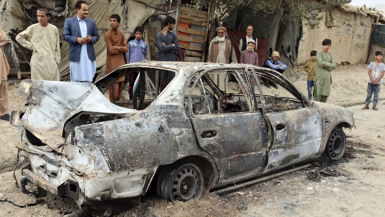 Locals view a vehicle damaged by a rocket attack in Kabul, Afghanistan, Monday, Aug. 30, 2021. (AP Photo/Khwaja Tawfiq Sediqi)