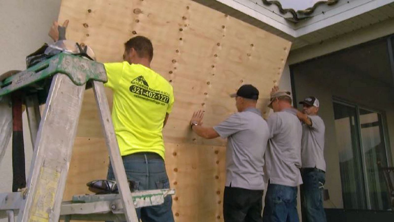 Contractors boarding up a home in Central Florida in preparation for Hurricane Dorian. (Spectrum News image)
