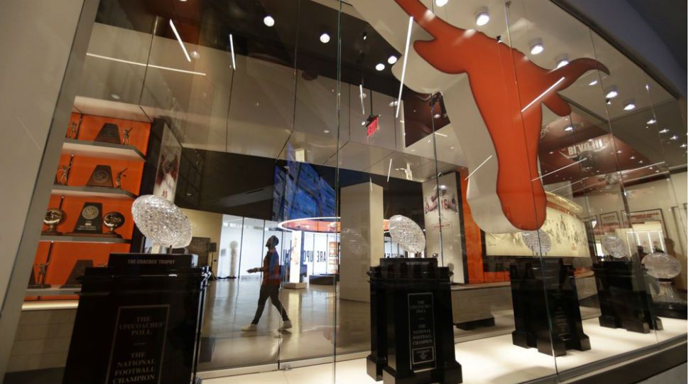 Former Texas football player Derrick Johnson, background, visits the Frank Denius Family University of Texas Athletics Hall of Fame, Friday, August 30, 2019, in Austin, Texas.  (AP Photo/Eric Gay)