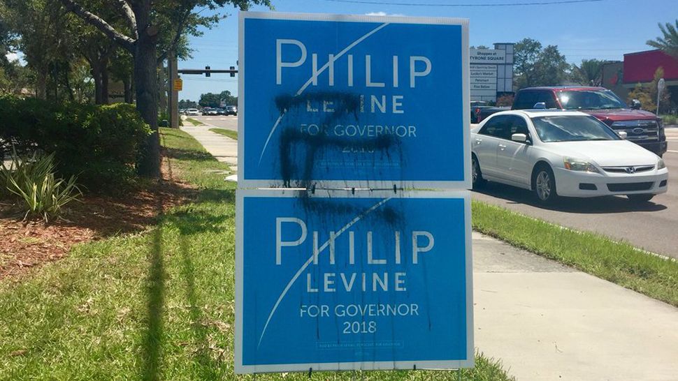 Campaign signs for Philip Levine defaced with swastika symbols.