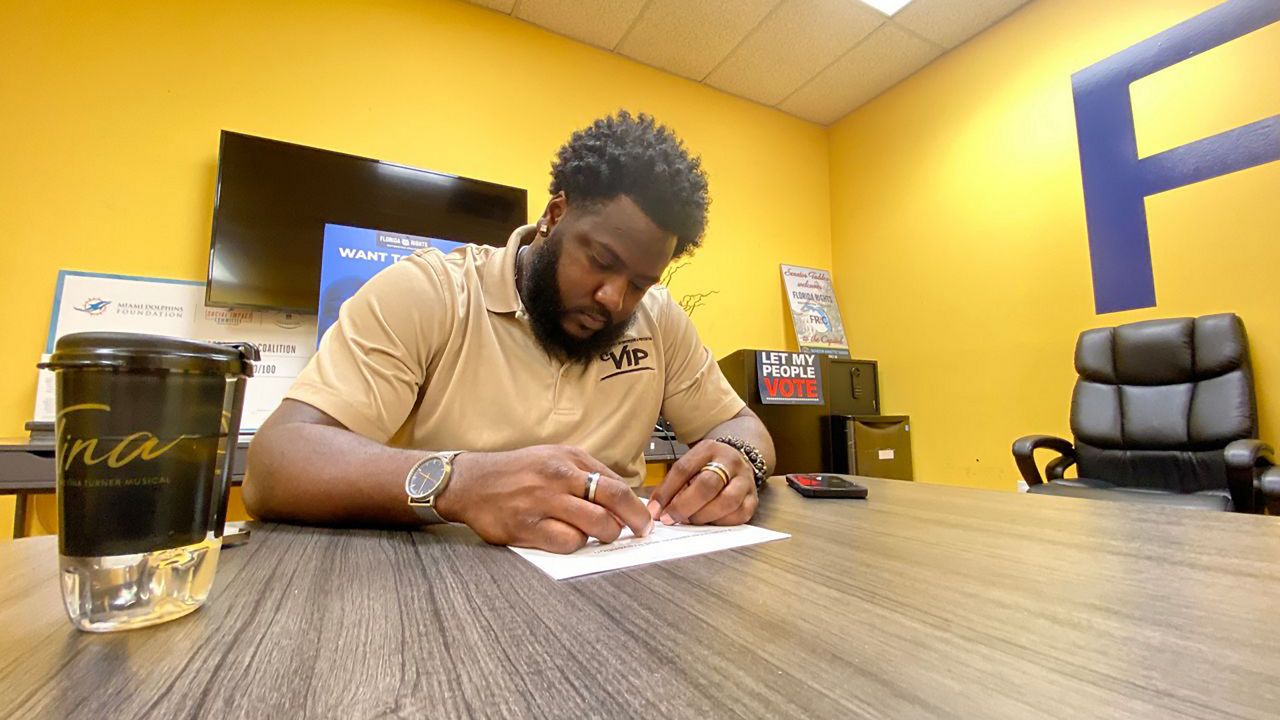 Raysean Brown looks through intake forms used to create individualized LifeMAPs for each CVI program fellow. (Spectrum News 13/Molly Duerig)