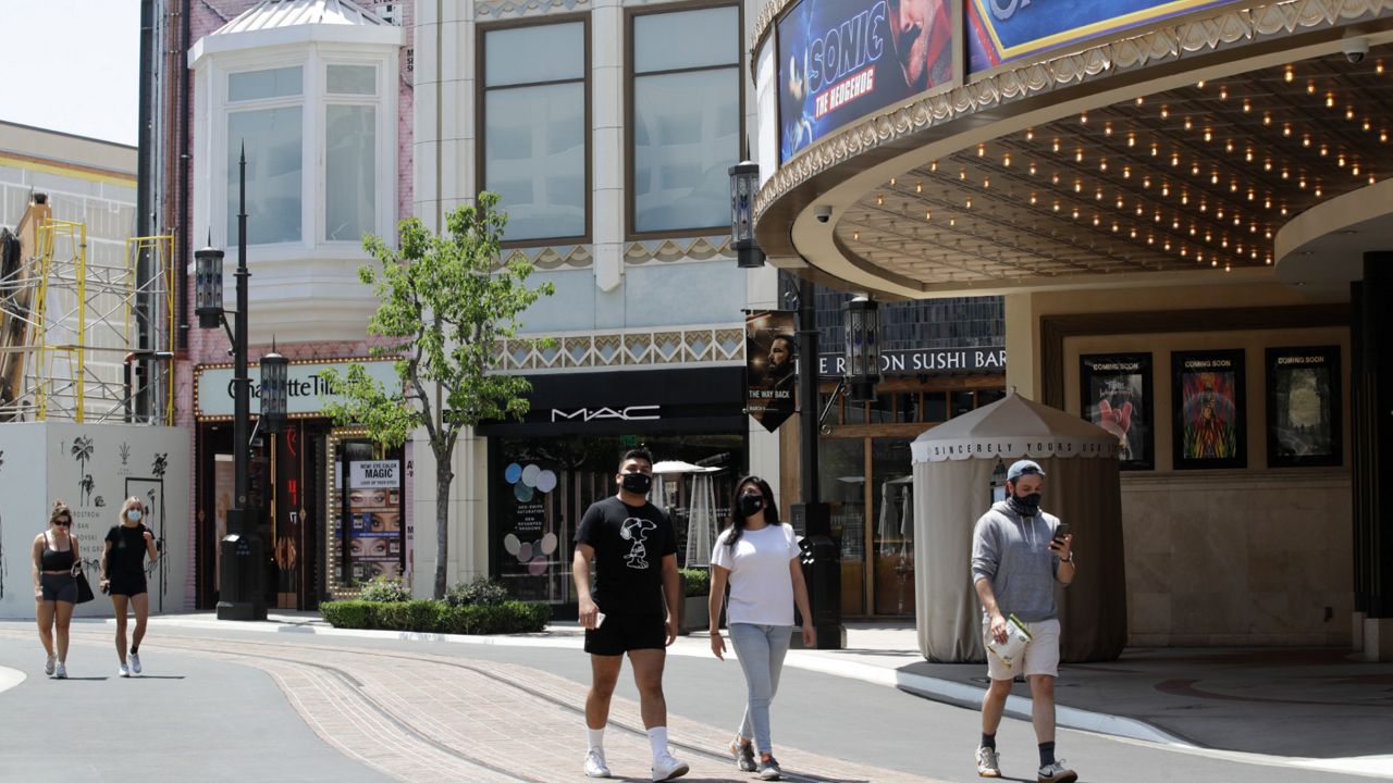 In this May 27, 2020, file photo, people walk in The Grove shopping center in Los Angeles. (AP Photo/Marcio Jose Sanchez, File)
