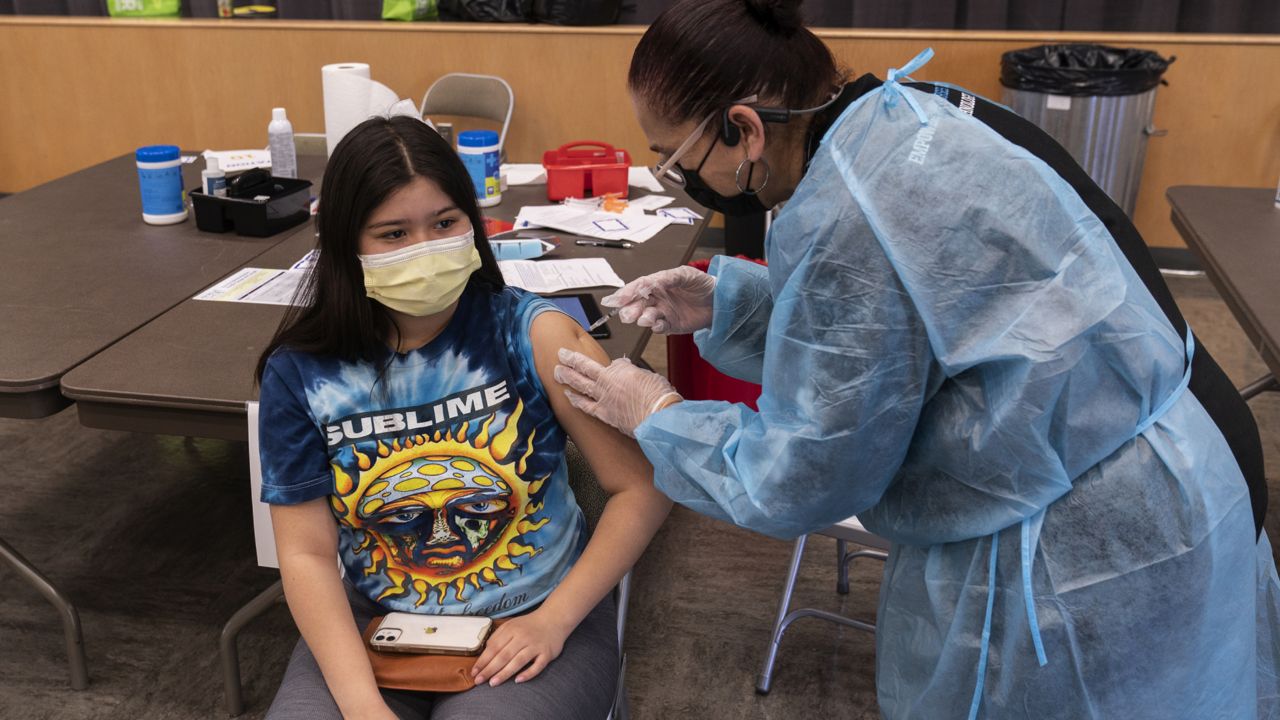 High school Akemi De La Luz, 17, is vaccinated at a school-based COVID-19 vaccination clinic for students 12 and older in San Pedro, Calif., Monday, May 24, 2021. (AP Photo/Damian Dovarganes)