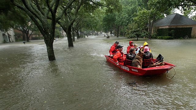 People in red boat during Hurricane Harvey floods. 