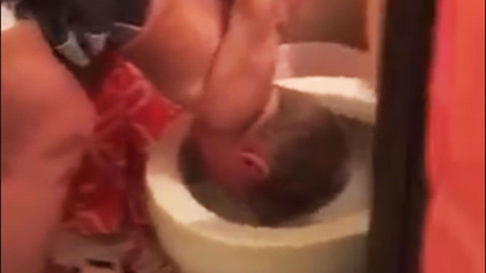 In a video posted to Facebook, a woman is seen dunking a young boy's head into a toilet. (Facebook)