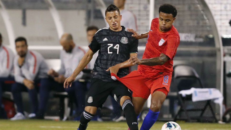 Mexico midfielder Roberto Alvarado (24) gets his hand caught in the uniform of U.S. midfielder Weston McKennie (8) during the second half of an international friendly soccer match Friday, Sept. 6, 2019, in East Rutherford, N.J. Mexico won 3-0. (AP Photo/Kathy Willens)