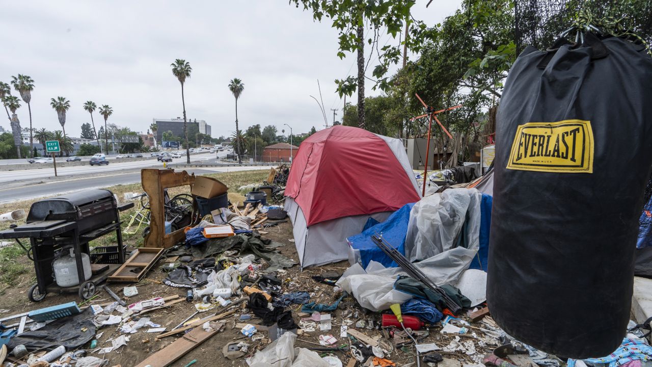 A trashed punching bag is left at a homeless encampment is seen on the side of the CA-101 highway in Echo Park neighborhood in Los Angeles on May 11, 2021. (AP Photo/Damian Dovarganes)