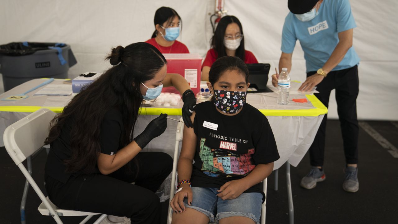 Mayra Navarrete, 13, receives the Pfizer COVID-19 vaccine from registered nurse, Noleen Nobleza at a clinic set up in the parking lot of CalOptima, Aug. 28, 2021, in Orange, Calif. (AP Photo/Jae C. Hong)