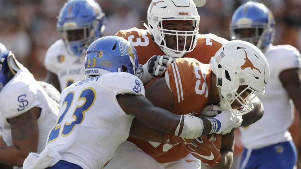 FILE - In this Sept. 9, 2017, file photo, Texas running back Chris Warren III (25) scores a touchdown past San Jose State safety Trevon Bierria (23) with the help of teammate Patrick Hudson (73) during the second half of an NCAA college football game in Austin, Texas. Hudson was taken to a hospital and treated in intensive care this week because of a heat-related illness at practice, coach Tom Herman said Thursday, Sept. 6, 2018. (AP Photo/Eric Gay, File)