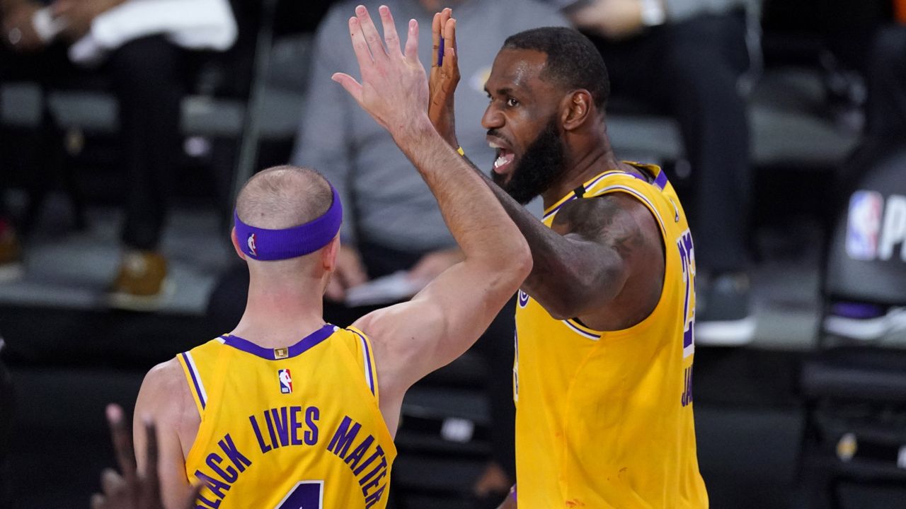 Los Angeles Lakers' LeBron James (23) celebrates with Alex Caruso (4) after scoring a basket while being fouled during the first half of an NBA conference semifinal playoff basketball game against the Houston Rockets Thursday, Sept. 10, 2020, in Lake Buena Vista, Fla. (AP Photo/Mark J. Terrill)