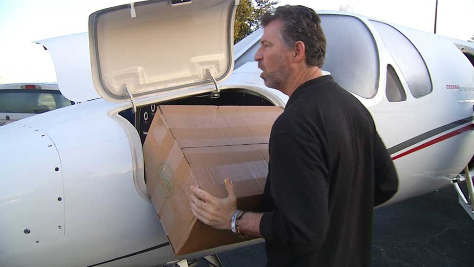 Lakeland business trainer Greg Coxe loads supplies bound for the Bahamas onto a jet at Lakeland Linder Airport. (Rick Elmhorst/Spectrum Bay News 9)