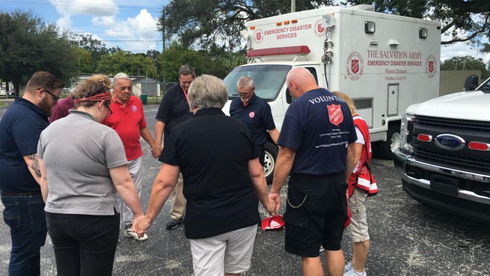 Salvation Army volunteers gather and pray before leaving for their deployment on Tuesday, Sept. 11, 2018. (Melissa Eichman, Spectrum Bay News 9)