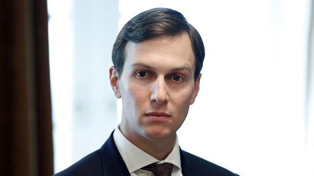 Jared Kushner, wearing a black suit jacket, a white dress shirt, and a burgundy tie.