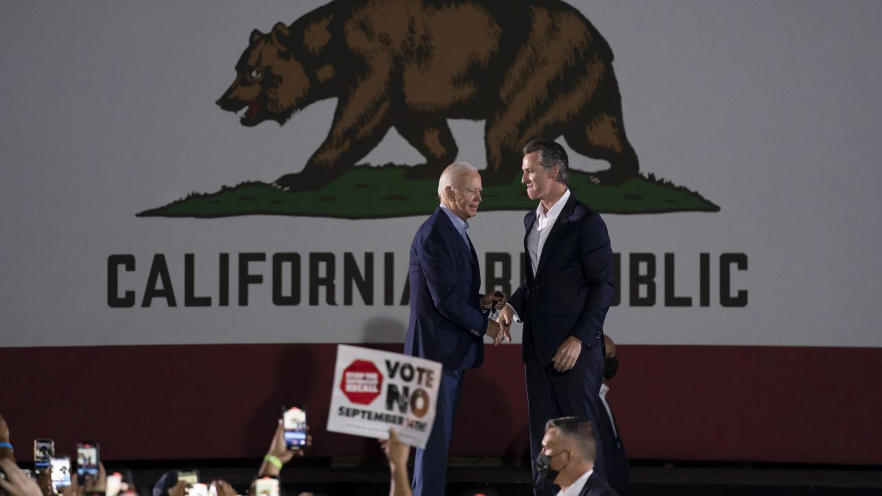 President Joe Biden, left, and California Gov. Gavin Newsom shake hands during a rally ahead of the California gubernatorial recall election Monday, Sept. 13, 2021, in Long Beach, Calif. (AP Photo/Jae C. Hong)