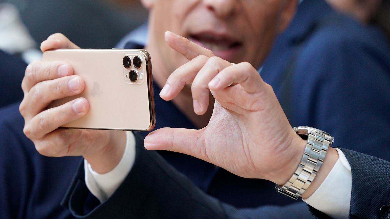 Photo of a person holding an iPhone 11 (AP Images)
