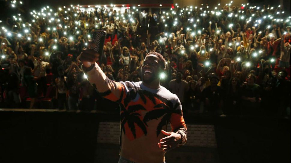 In this Sept. 12, 2018 photo, comedian and actor Kevin Hart films himself with a cellphone after talking to the students at Booker T. Washington High School in Dallas. Hart was named principal for the day. Hart was in town promoting his new movie, Night School. (Vernon Bryant/The Dallas Morning News via AP)