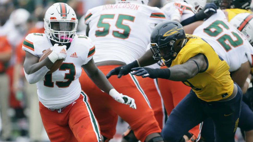 Miami running back DeeJay Dallas (13) is pursued by Toledo defensive lineman Tuzar Skipper during the first half of an NCAA college football game, Saturday, Sept. 15, 2018, in Toledo, Ohio. (AP Photo/Duane Burleson)