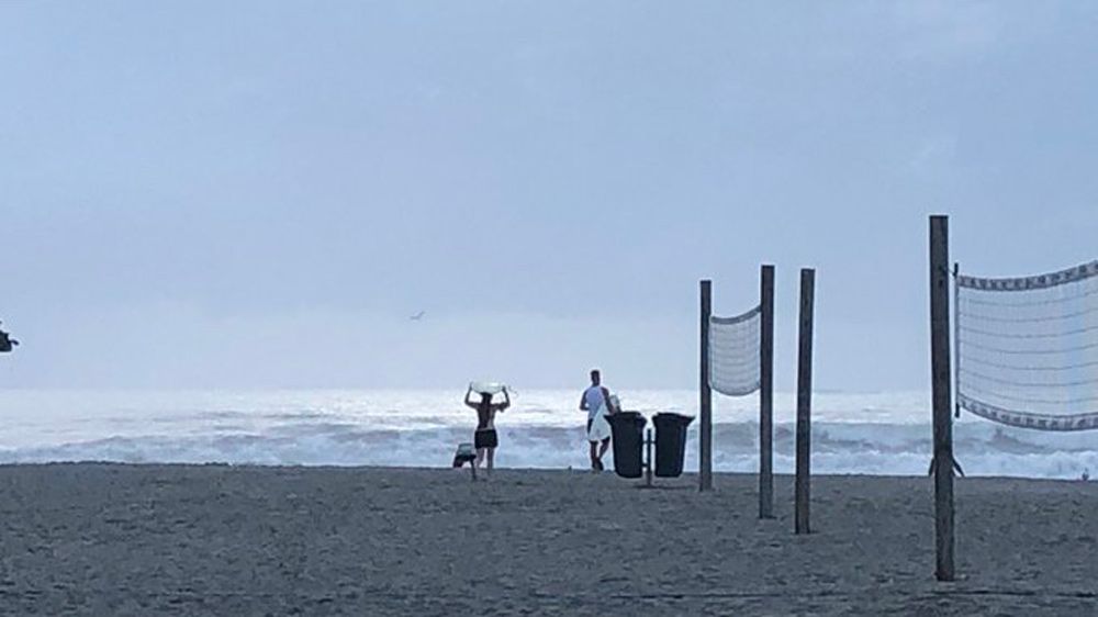 Surfers head out onto Cocoa Beach Sunday morning. (Rebecca Turco, Spectrum News)