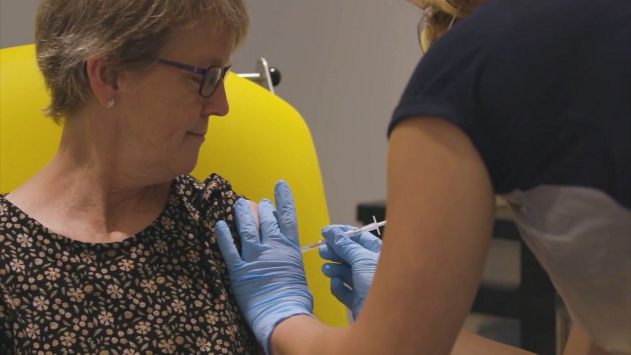 A woman receives a flu shot in the arm