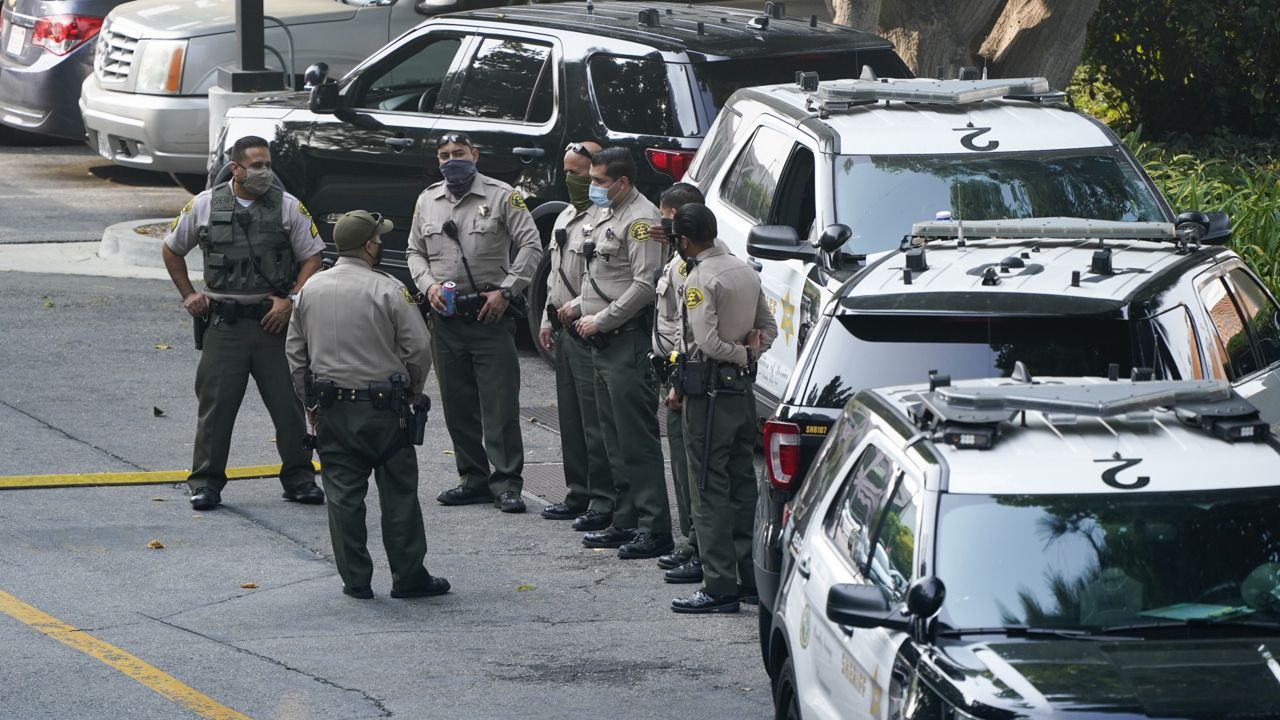 Police officers stand outside St. Francis Medical Center on Monday, Sept. 14, 2020, in Lynwood, Calif. Two Los Angeles County Sheriff's deputies were shot in an apparent ambush Saturday. (AP Photo/Ashley Landis)