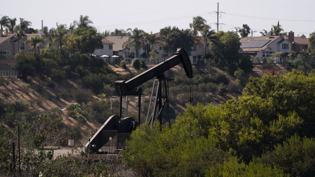 Homes are seen behind a pump jack operating at the Inglewood Oil Field in Los Angeles, Tuesday, May 18, 2021. (AP Photo/Jae C. Hong)