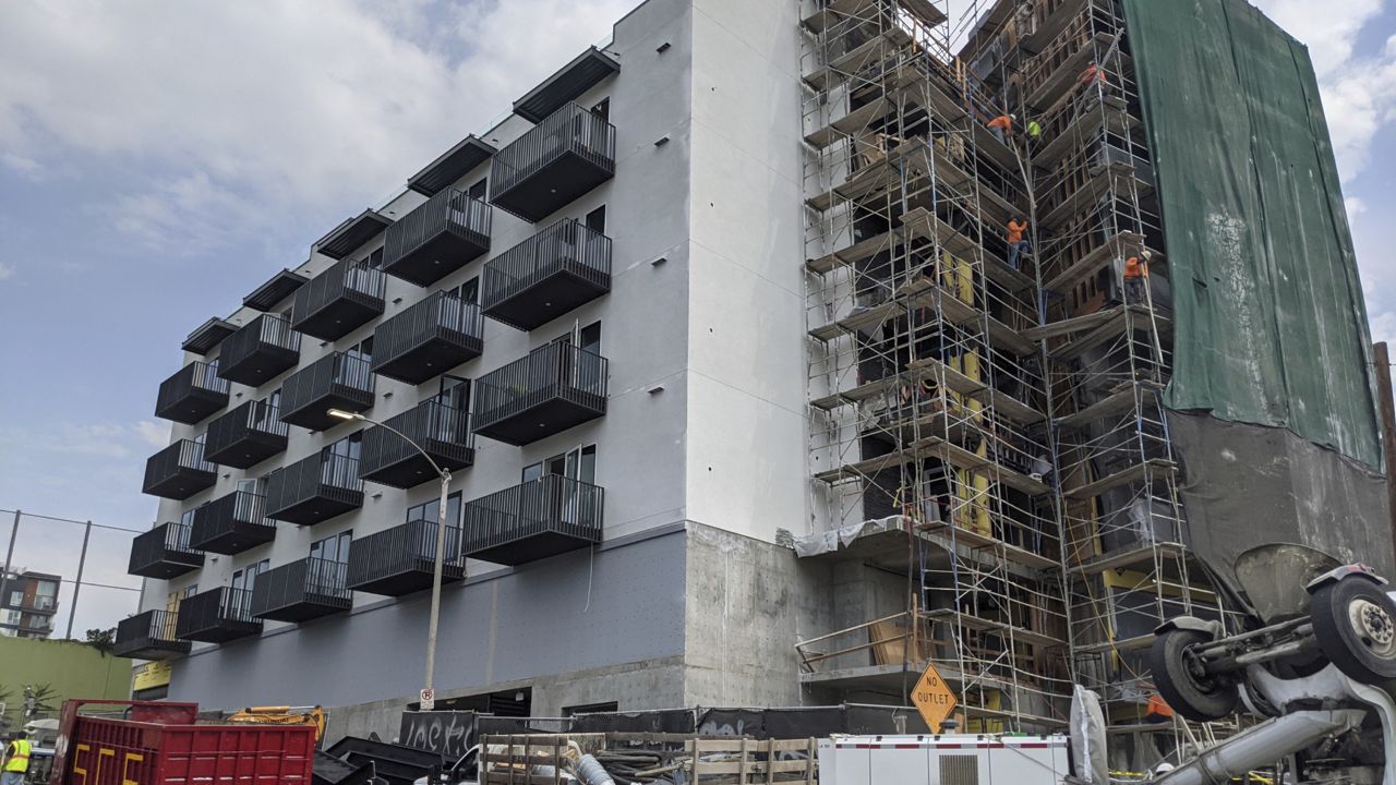 In this June 18, 2021, photo, construction workers finish the exterior of an apartment building downtown Los Angeles. California Gov. (AP Photo/Damian Dovarganes)