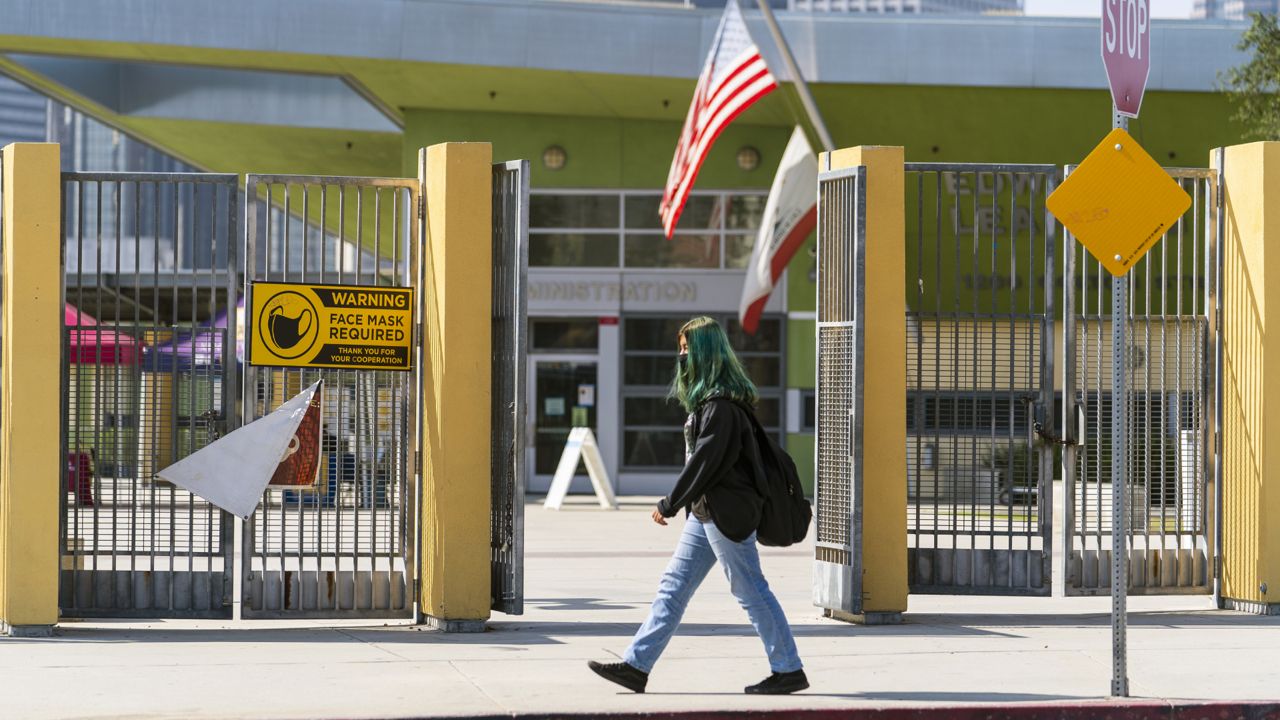 A student walks past the open doors of the Edward R. Roybal Learning Center in Los Angeles Thursday Sept. 9, 2021. (AP Photo/Damian Dovarganes)