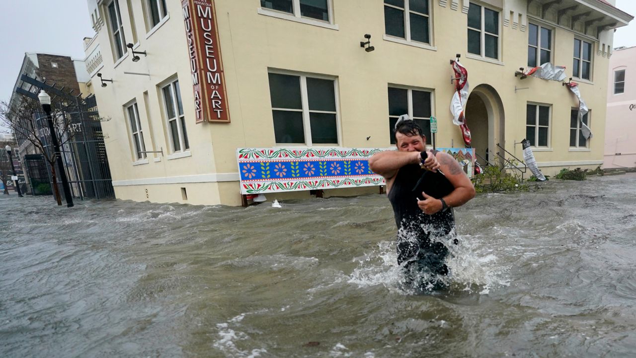 Trent Airhart wades through floodwaters in downtown Pensacola, Florida, after Hurricane Sally made landfall Wednesday near Gulf Shores, Alabama, as a Category 2 storm. (Gerald Herbert/AP)