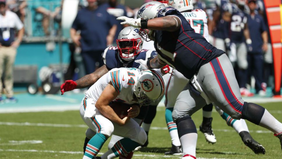 Miami Dolphins quarterback Ryan Fitzpatrick (14) ducks asNew England Patriots outside linebacker Elandon Roberts (52) and defensive tackle Danny Shelton (71) close in for a sack, during the second half at an NFL football game, Sunday, Sept. 15, 2019, in Miami Gardens, Fla. (AP Photo/Wilfredo Lee)