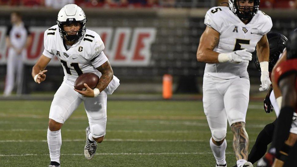 Central Florida quarterback Dillon Gabriel (11) runs through an opening in the Louisville defensive line during the first half of an NCAA college football game in Louisville, Ky., Friday, Sept. 17, 2021. (AP Photo/Timothy D. Easley)