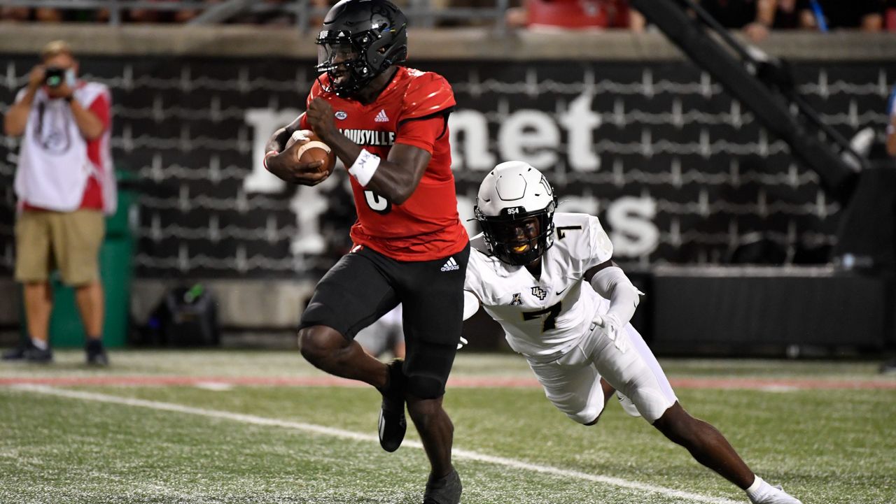 Louisville quarterback Malik Cunningham (3) runs from the grasp of UCF defensive back Davonte Brown in the teams' 2021 matchup. (AP Photo/Timothy D. Easley)