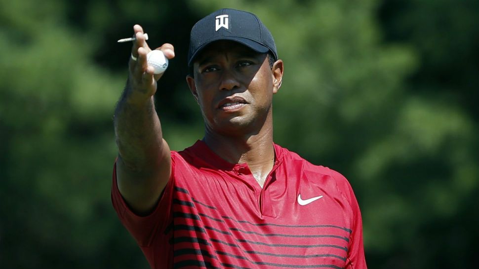 FILE - In this Monday, Sept. 3, 2018, file photo, Tiger Woods indicates the direction of the wind before teeing off on the third hole during the final round of the Dell Technologies Championship golf tournament at TPC Boston in Norton, Mass. Woods once took for granted that he would end his season at the Tour Championship. Now, just being at East Lake feels like an accomplishment. (AP Photo/Michael Dwyer, File)