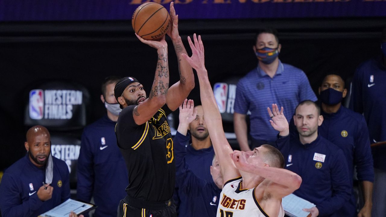 Los Angeles Lakers' Anthony Davis (3) shoots a 3-point basket over Denver Nuggets' Nikola Jokic (15) at the end of an NBA conference final playoff basketball game Sunday, Sept. 20, 2020, in Lake Buena Vista, Fla. The Lakers won 105-103. (AP Photo/Mark J. Terrill)