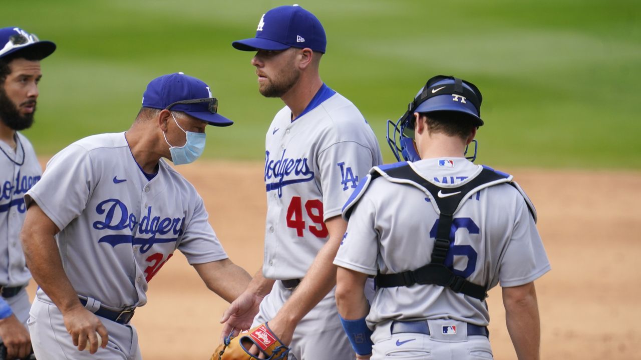 Dodgers manager Dave Roberts, left, pulls relief pitcher Blake Treinen from the mound as catcher Will Smith looks on in the sixth inning of a baseball game Sunday, Sept. 20, 2020, in Denver. (AP/David Zalubowski)