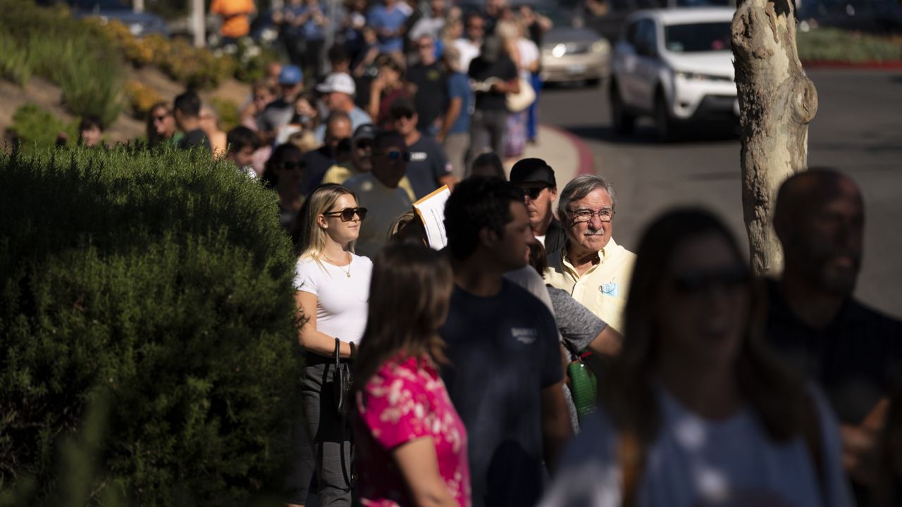 People wait in line outside a vote center to cast their ballots, Tuesday, Sept. 14, 2021, in Huntington Beach, Calif. (AP Photo/Jae C. Hong)