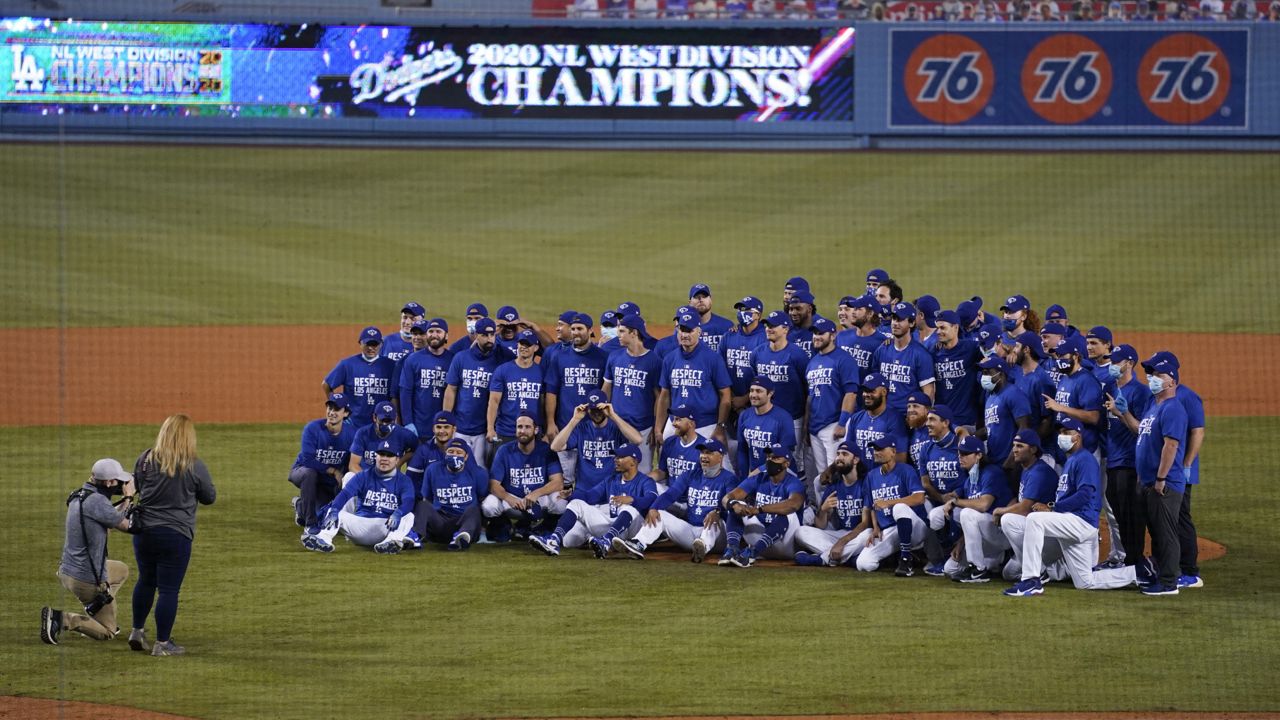 The Los Angeles Dodgers pose for a photo after a 7-2 win over the Oakland Athletics in a baseball game, which clinched the NL West title for the Dodgers on Tuesday, Sept. 22, 2020, in Los Angeles. (AP Photo/Ashley Landis)