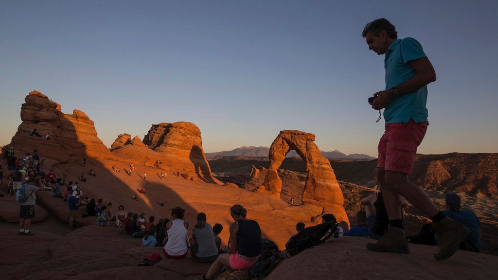 People gather to watch the sunset at Delicate Arch in Arches National Park near Moab, Utah, Sept. 8, 2016. (Spenser Heaps/The Deseret News via AP, File)