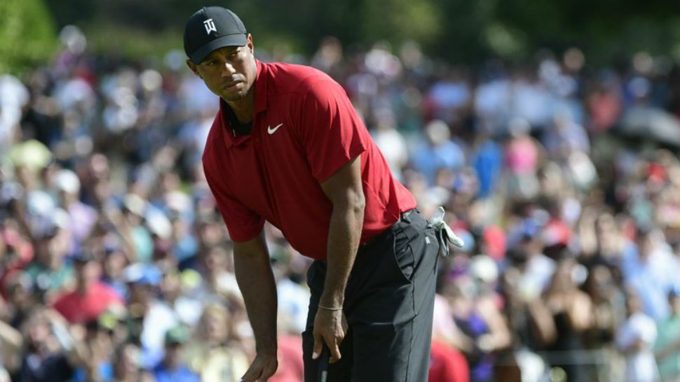 Tiger Woods motions for his putt for birdie to slow down as it passes the ninth hole during the final round of the Tour Championship golf tournament Sunday, Sept. 23, 2018, in Atlanta. (AP Photo/John Amis)