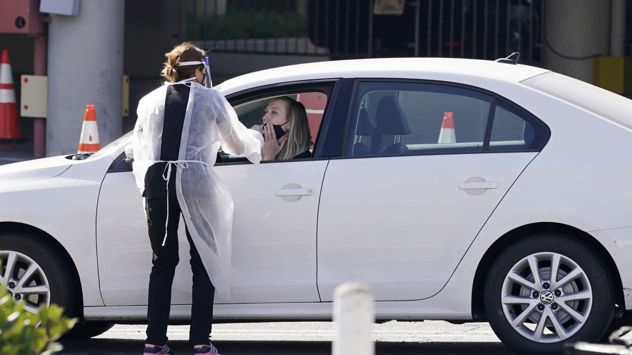 A driver gets a coronavirus test before entering the parking lot for the 72nd Primetime Emmy Awards at Staples Center, Sunday, Sept. 20, 2020, in Los Angeles. (AP Photo/Chris Pizzello)