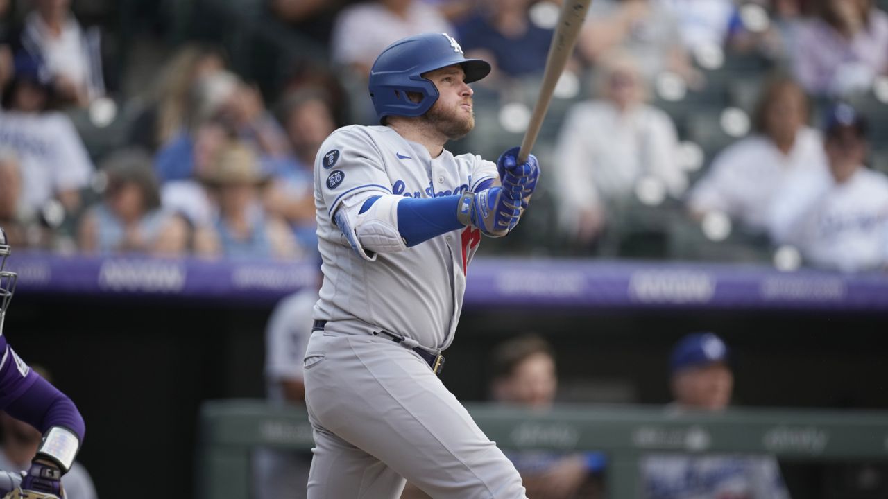 Los Angeles Dodgers' Max Muncy follows the flight of his two-run home run off Colorado Rockies relief pitcher Lucas Gilbreath in the 10th inning of a baseball game Thursday, Sept. 23, 2021, in Denver. (AP Photo/David Zalubowski)