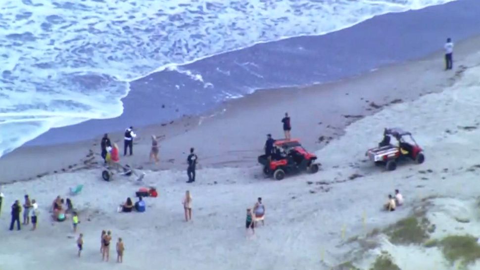 Brevard Ocean Rescue officials search for a Kissimmee man who was pulled out by a rip current at Cocoa Beach on Monday. (Sky 13)