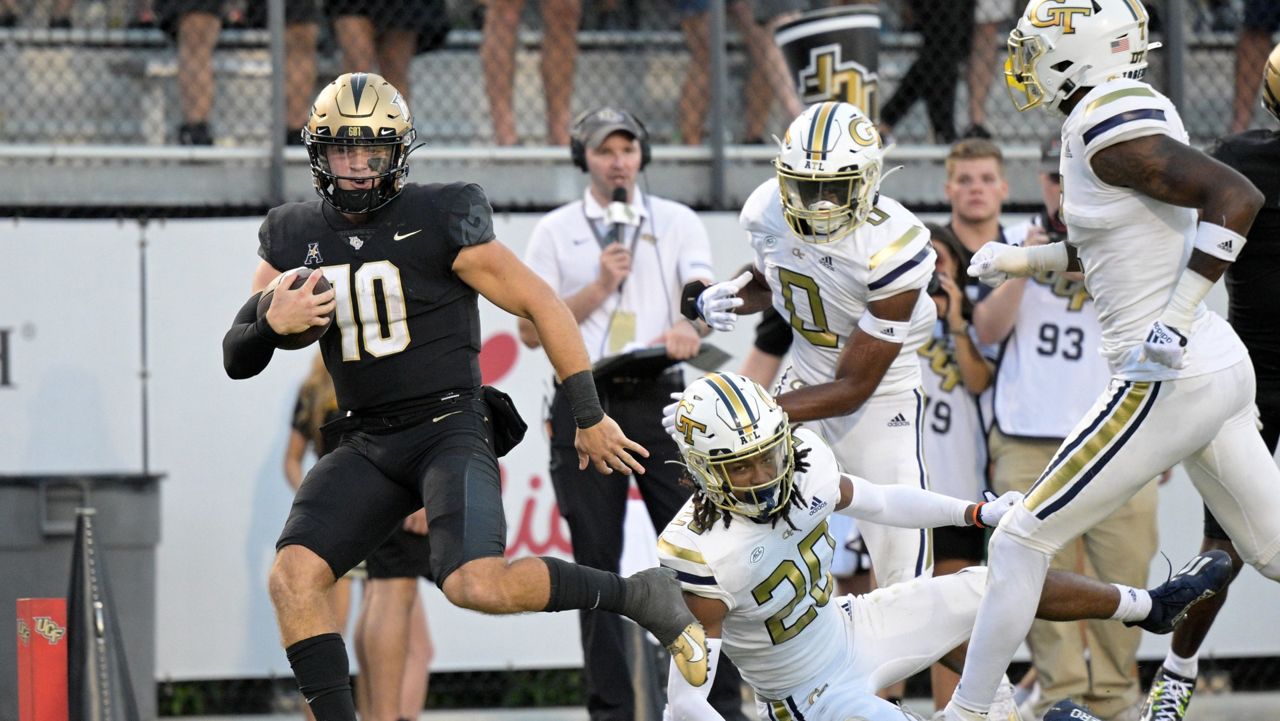 Central Florida quarterback John Rhys Plumlee (10) rushes for a 28-yard touchdown past Georgia Tech defensive backs LaMiles Brooks (20), Myles Sims (0) and Zamari Walton (right) during the 2nd half Saturday. (AP Photo/Phelan M. Ebenhack)