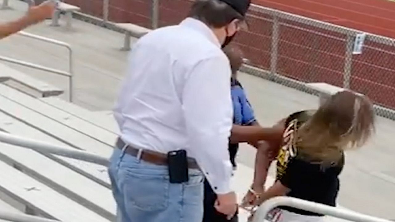 Woman being handcuffed at a stadium