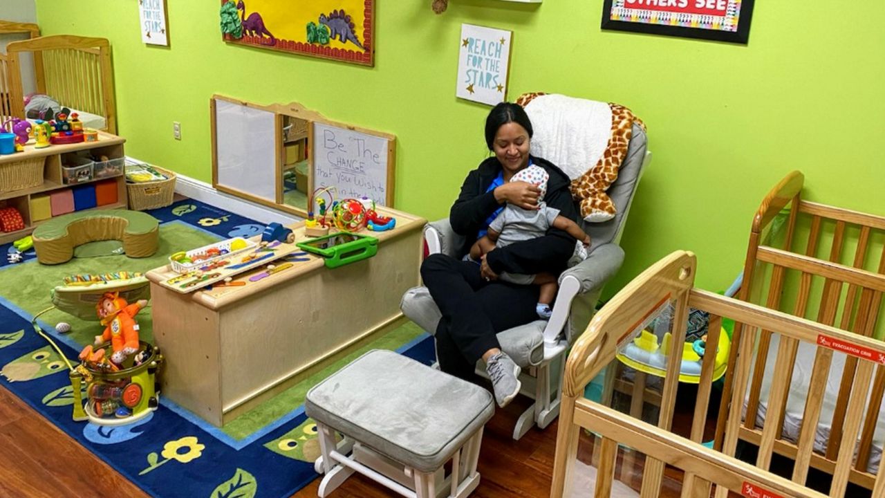 Kelly Lynch, a preschool teacher at Coalition for the Homeless of Central Florida, sits in for a colleague in the facility's nursery. (Pete Reinwald/Spectrum News 13)
