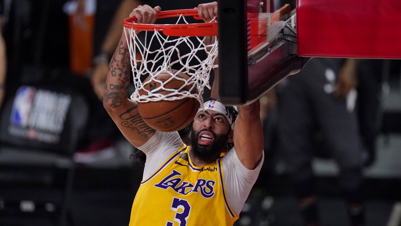Los Angeles Lakers' Anthony Davis (3) slams a dunk against the Miami Heat during the second half of Game 1 of basketball's NBA Finals Wednesday, Sept. 30, 2020, in Lake Buena Vista, Fla. (AP Photo/Mark J. Terrill)